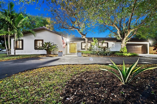 view of front facade featuring a garage, driveway, and stucco siding