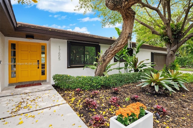 property entrance featuring stucco siding and an attached garage