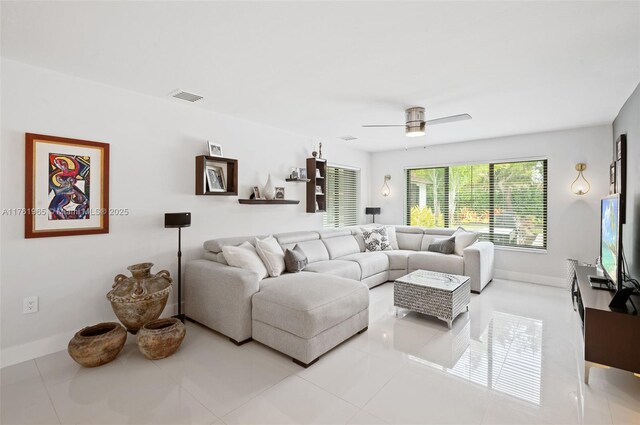 tiled living area with a notable chandelier, visible vents, and baseboards