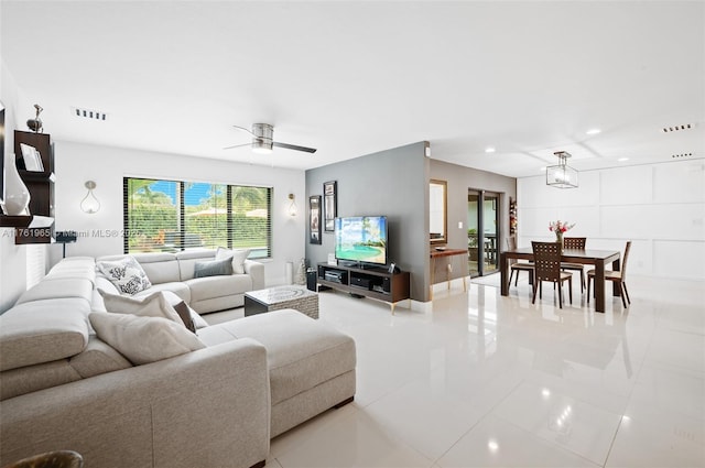 living area featuring light tile patterned floors, visible vents, ceiling fan with notable chandelier, and recessed lighting