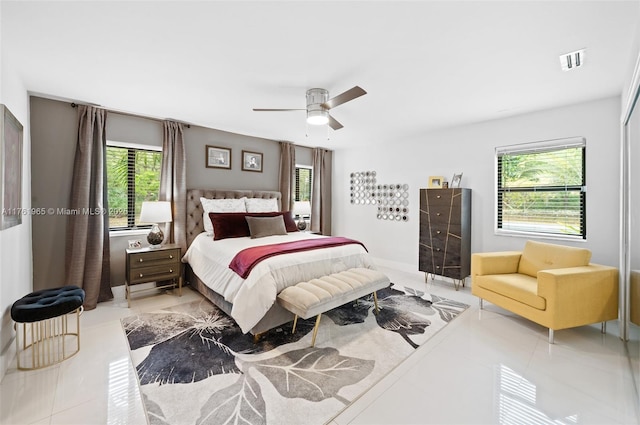 bedroom with light tile patterned floors, a ceiling fan, and visible vents