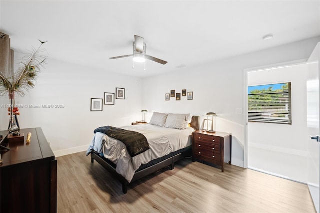 bedroom with a closet, baseboards, wood finished floors, and a ceiling fan