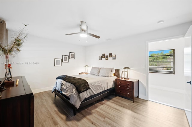 bedroom featuring a ceiling fan, baseboards, and light wood finished floors