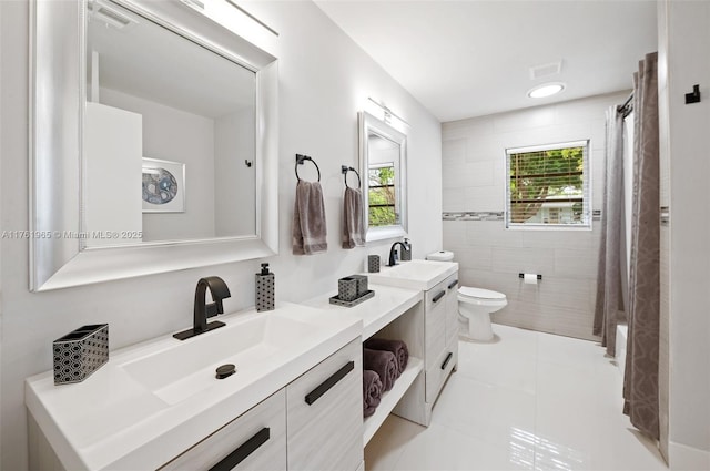 full bathroom featuring tile patterned floors, double vanity, toilet, and a sink