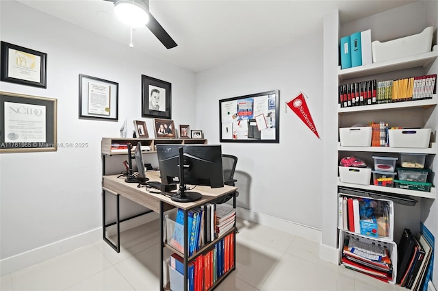 tiled office space featuring baseboards and a ceiling fan