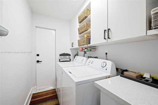 laundry room featuring baseboards, cabinet space, and washing machine and clothes dryer