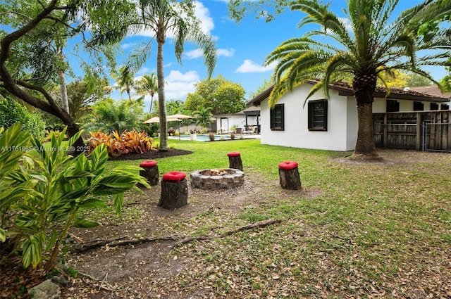 view of yard featuring a fire pit and fence