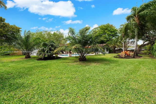 view of yard featuring fence and an outdoor pool