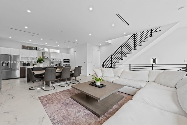 living room with recessed lighting, marble finish floor, stairway, and visible vents