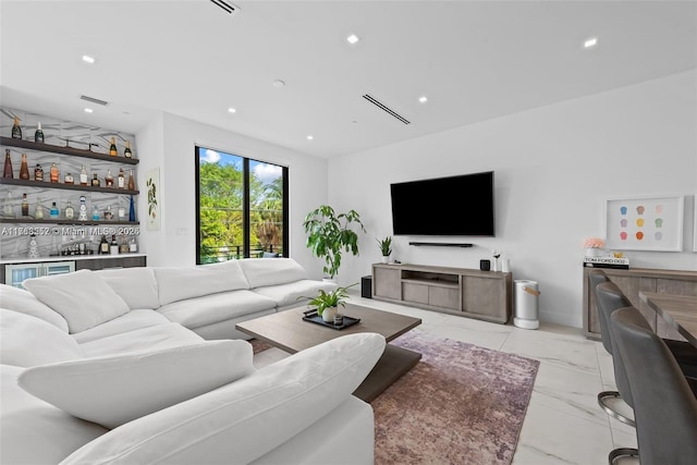 living area featuring recessed lighting, marble finish floor, and a dry bar