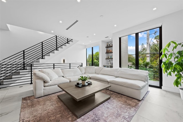 living area featuring recessed lighting, visible vents, plenty of natural light, and stairs