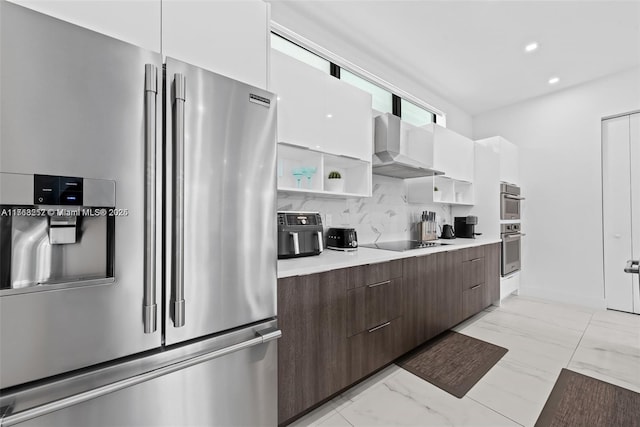 kitchen with modern cabinets, marble finish floor, appliances with stainless steel finishes, and wall chimney range hood