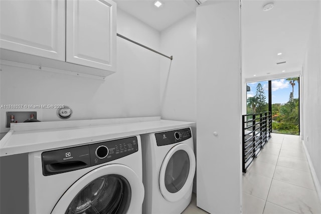 laundry area with washer and dryer, cabinet space, and light tile patterned flooring