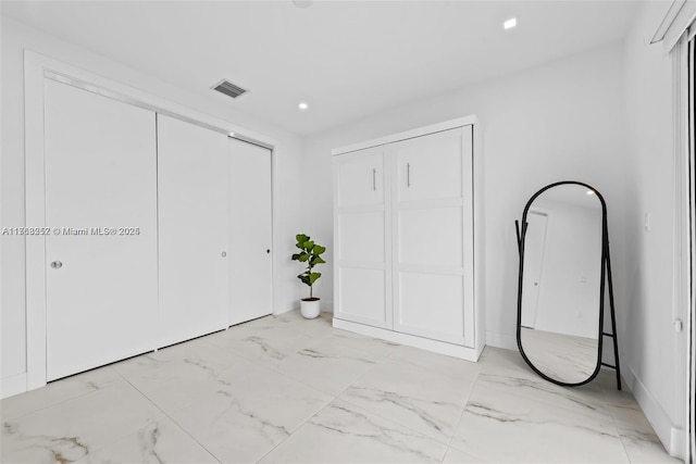 unfurnished bedroom with recessed lighting, visible vents, and marble finish floor