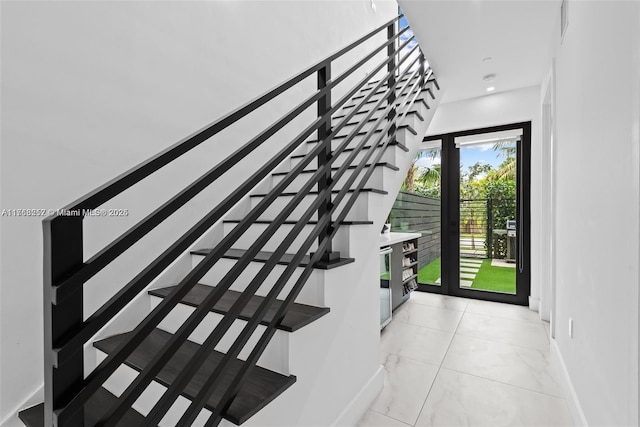 stairs featuring baseboards and marble finish floor