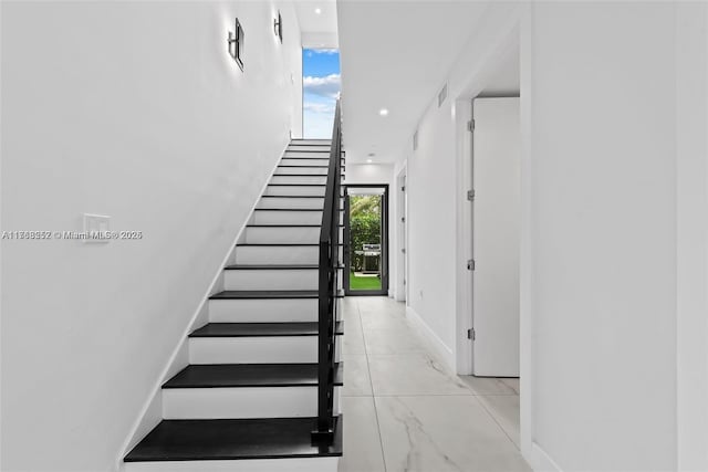 stairway featuring visible vents and baseboards