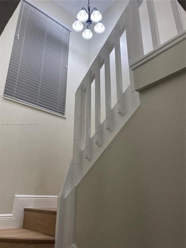 staircase featuring a chandelier