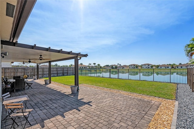 view of patio with outdoor dining area, a water view, a fenced backyard, and a ceiling fan