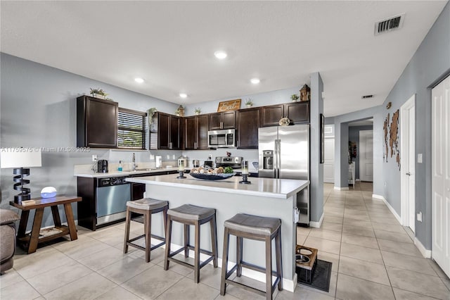 2548 SE 1st St, Homestead, FL 33033 - kitchen with light countertops, a sink, light tile patterned flooring, dark brown cabinetry, and appliances with stainless steel finishes