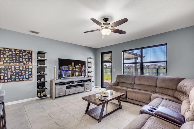 living room featuring light tile patterned flooring, visible vents, baseboards, and ceiling fan