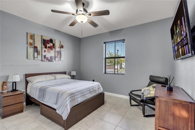 bedroom with light tile patterned floors, baseboards, a textured ceiling, and ceiling fan