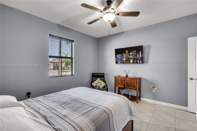 bedroom with light tile patterned floors, ceiling fan, and baseboards