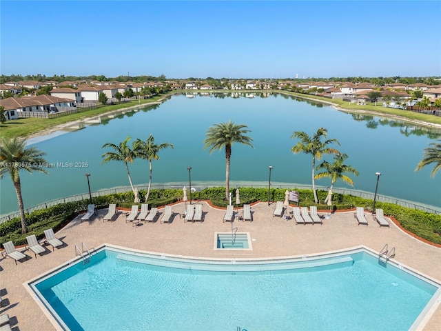 community pool featuring a water view, fence, and a patio area