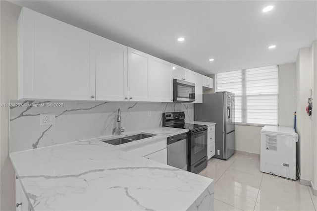 kitchen featuring a sink, light stone countertops, appliances with stainless steel finishes, and white cabinets