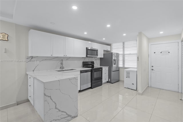 kitchen with light stone counters, a sink, stainless steel appliances, white cabinetry, and tasteful backsplash