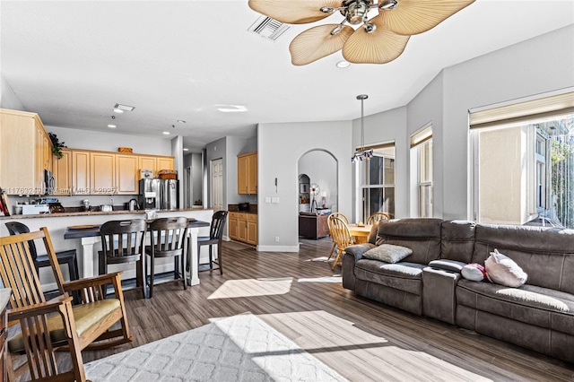 living room with visible vents, recessed lighting, arched walkways, dark wood-style flooring, and ceiling fan