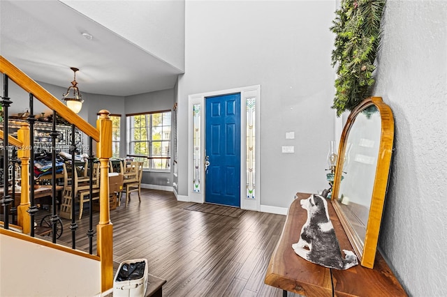 entryway with stairway, baseboards, and wood finished floors