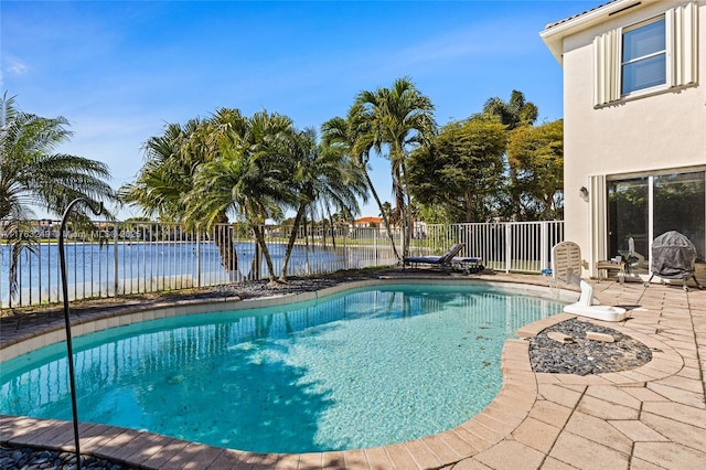 view of swimming pool featuring a patio area, a fenced in pool, a water view, and fence