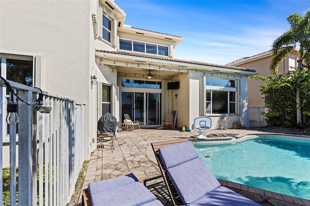 rear view of house featuring a ceiling fan, a patio area, fence, and stucco siding