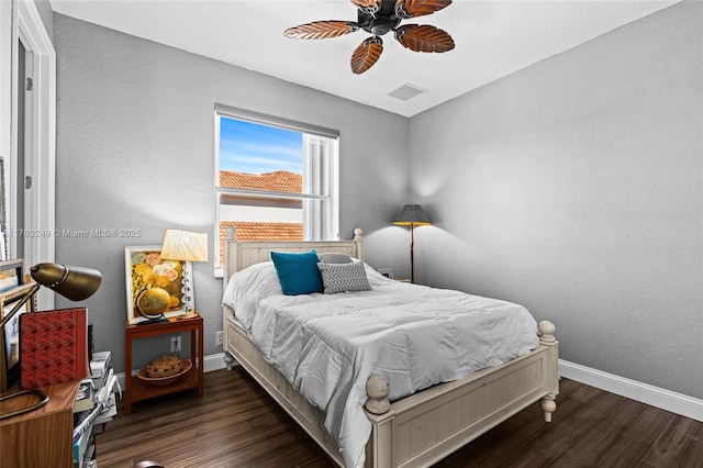 bedroom with visible vents, a ceiling fan, baseboards, and wood finished floors