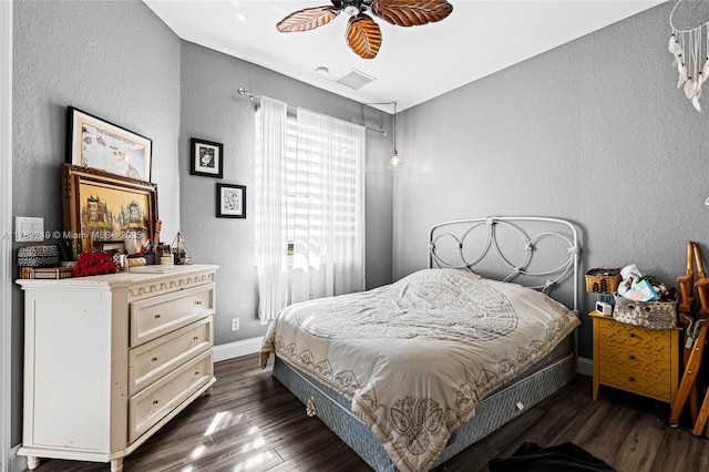 bedroom featuring baseboards, dark wood-style floors, a ceiling fan, and a textured wall