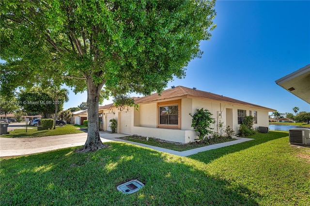 view of front of home with stucco siding, driveway, cooling unit, a front yard, and an attached garage