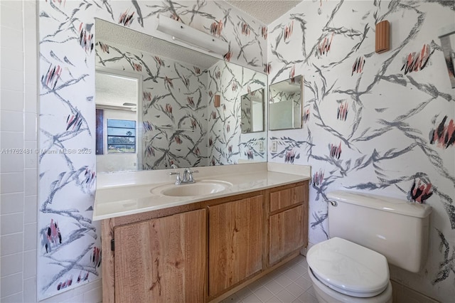 bathroom featuring wallpapered walls, toilet, and a textured ceiling