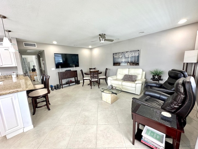 living room with visible vents, ceiling fan, light tile patterned floors, recessed lighting, and a textured ceiling