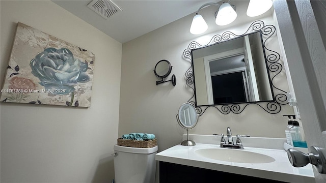 bathroom with visible vents, toilet, and vanity