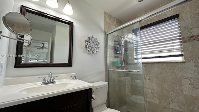 bathroom featuring vanity, a shower stall, and toilet