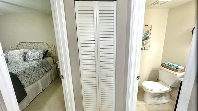 tiled bedroom with a closet and visible vents