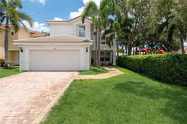 mediterranean / spanish-style home with a front lawn, a tiled roof, stucco siding, decorative driveway, and a garage