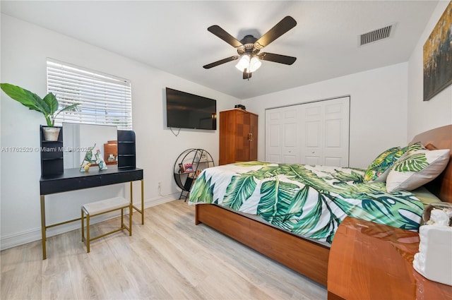 bedroom with visible vents, ceiling fan, baseboards, wood finished floors, and a closet