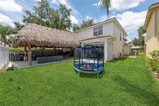 exterior space featuring a patio, a trampoline, and a fenced backyard