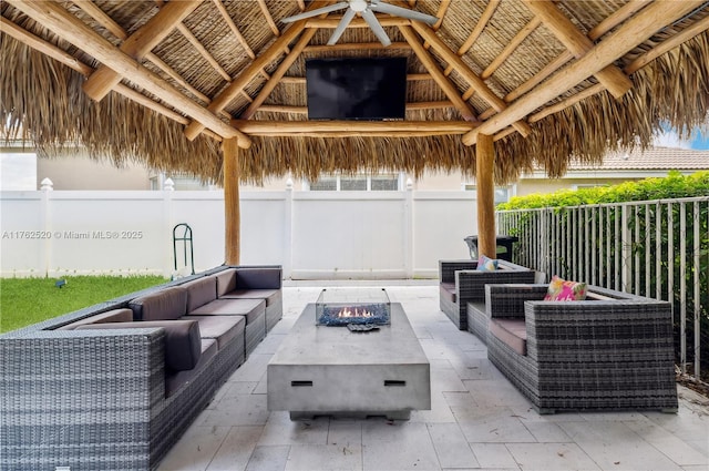 view of patio / terrace with a gazebo, an outdoor living space with a fire pit, and fence