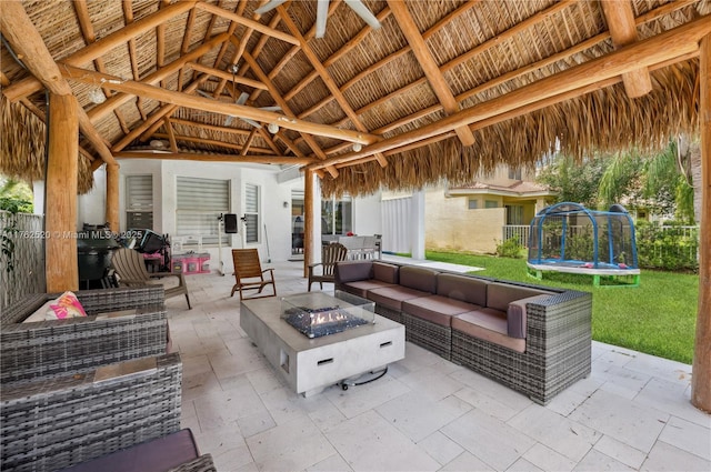 view of patio / terrace with a gazebo, a trampoline, and an outdoor living space with a fire pit