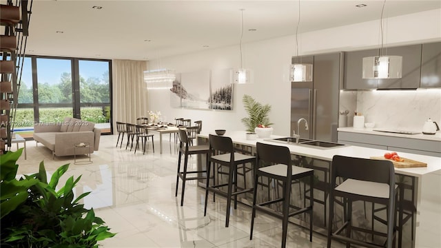 kitchen with tasteful backsplash, a kitchen bar, light countertops, marble finish floor, and a sink