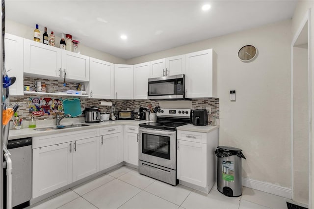 kitchen featuring white cabinetry, light countertops, appliances with stainless steel finishes, and a sink