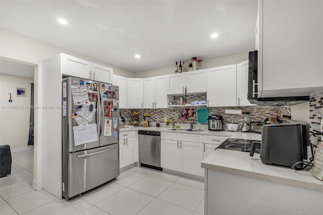 kitchen featuring light tile patterned floors, stainless steel appliances, decorative backsplash, and white cabinetry