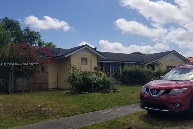 view of side of home featuring a yard and stucco siding